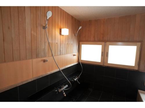 un bagno con doccia e lavandino e due finestre di Guest House Tou - Vacation STAY 26356v a Kushiro