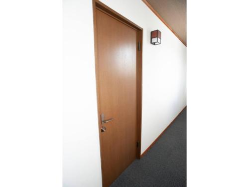 un corridoio con porta in legno e scala di Guest House Tou - Vacation STAY 26352v a Kushiro