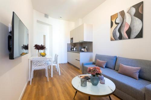 a living room with a blue couch and a table at Hidden Art Boutique Residence by Dwellfort in Prague