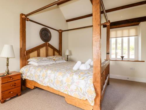 a bedroom with a wooden bed with a wooden frame at Wheal Kitty in Newlyn East