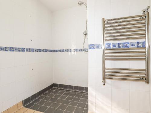 a bathroom with a shower and a tile floor at Wheal Kitty in Newlyn East