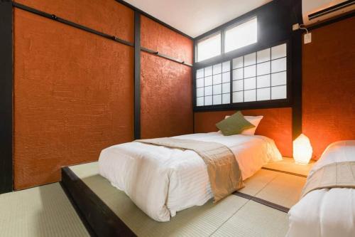 a bedroom with a large bed and a window at Oyado NAKAZ1 - Vacation STAY 27690v in Osaka