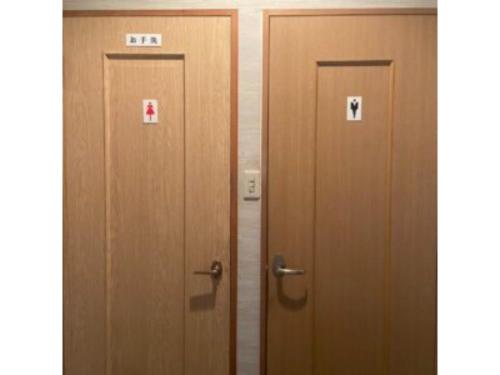2 puertas de madera con carteles en una habitación en Asobiyahouse Iki - Vacation STAY 30413v en Iki