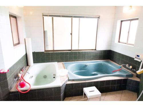 a bathroom with a blue tub and a window at Asobiyahouse Iki - Vacation STAY 30413v in Iki