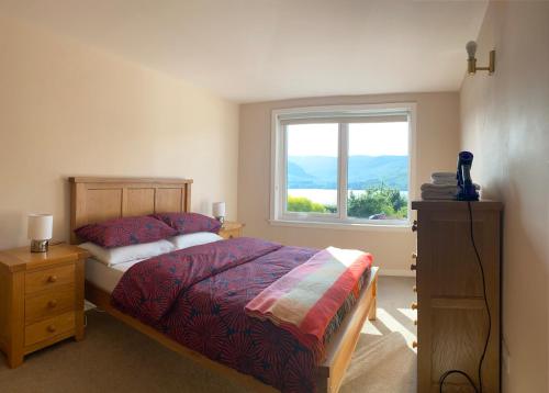 1 dormitorio con cama y ventana en Borrodale, one bedroom apartment with balcony and loch view., en Fort William
