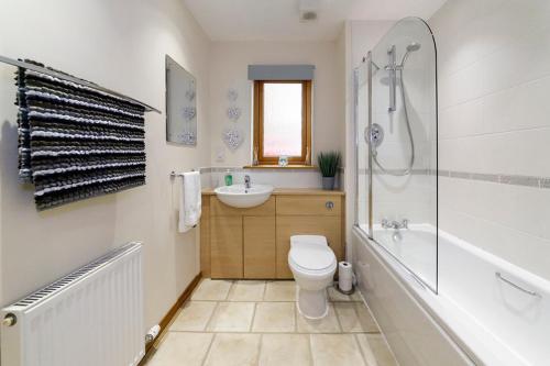 a bathroom with a toilet and a sink and a shower at Modern 2 Bedroom Semi detached House with own private driveway in Inverness