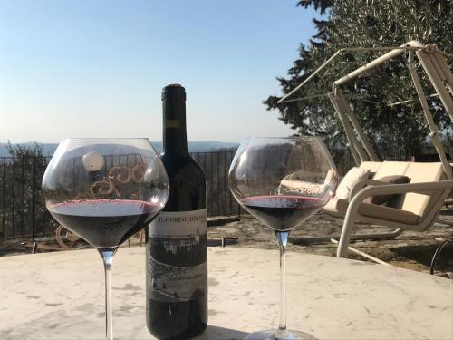 a bottle of wine and two glasses on a table at Il Fiorino di Badia in Badia A Passignano