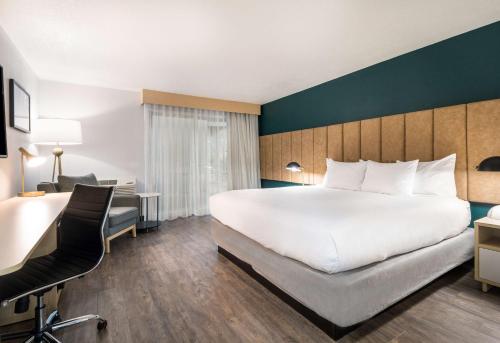 a hotel room with a large bed and a desk at Best Western Portland West Beaverton in Portland