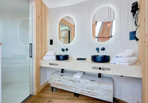 a bathroom with two sinks and two mirrors at Glamping El Regajo Valle del Jerte in El Torno