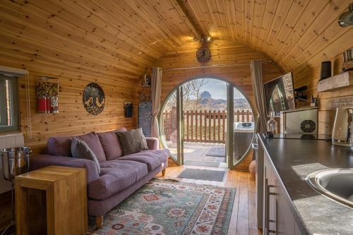 a living room with a purple couch and a kitchen at Suilven view in Lochinver