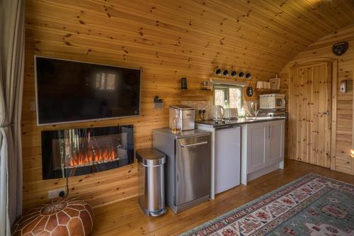 a kitchen with a fireplace in a log cabin at Suilven view in Lochinver