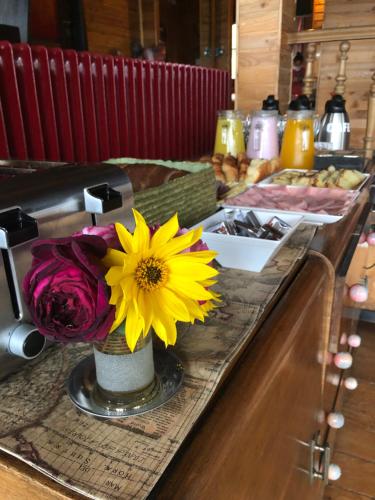 a table with a vase with a yellow flower on it at La Miralejos in San Carlos de Bariloche