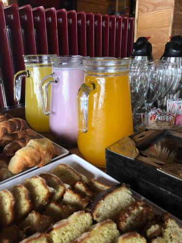 a table topped with jars of orange juice and pastries at La Miralejos in San Carlos de Bariloche