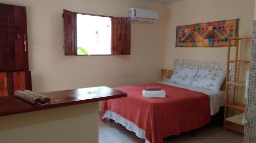 a small bedroom with a bed with a red blanket at Flores do Riacho in São Miguel dos Milagres