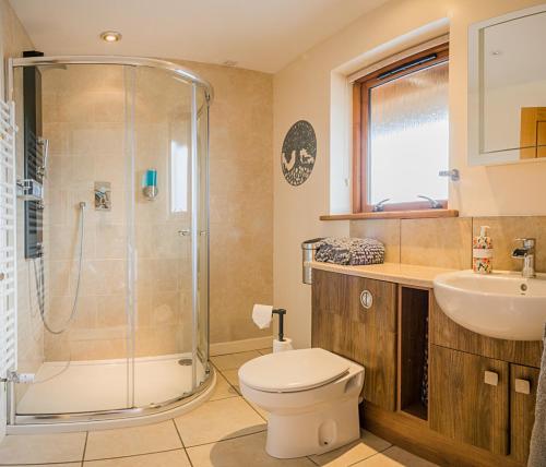 a bathroom with a shower and a toilet and a sink at Waterloo House in Lochinver