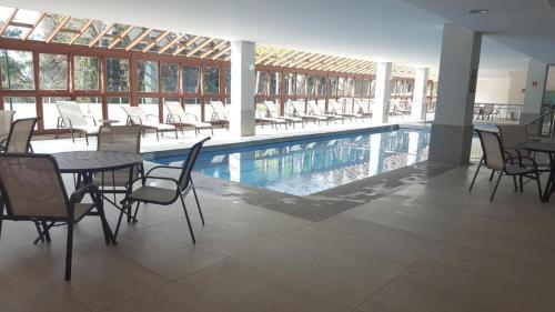 ペドラ・アズールにあるFlat Vista Azul Hotelのスイミングプール(椅子、テーブル、テーブル付)