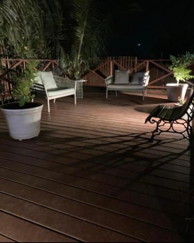 two chairs and a table on a deck at night at Flats Baia dos Porcos in Fernando de Noronha