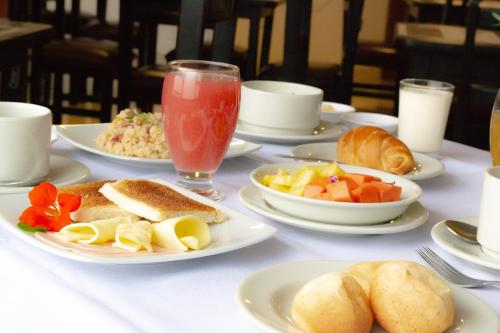 a white table with plates of food and drinks at Hotel Virrey Central in Bogotá