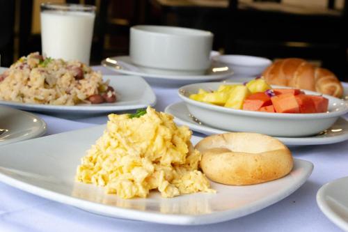 a table with plates of breakfast foods on it at Hotel Virrey Central in Bogotá