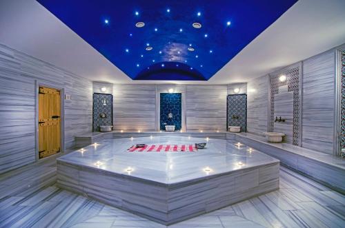 a room with a large white tub with a blue ceiling at Palm Wings Kusadasi Beach Resort&Spa in Davutlar