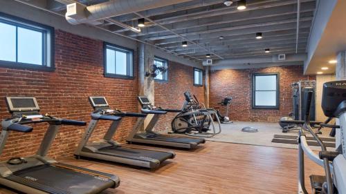 einen Fitnessraum mit mehreren Laufbändern und einer Ziegelwand in der Unterkunft Hotel Indigo - Omaha Downtown by IHG in Omaha