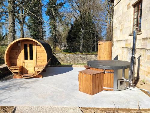 een houten hobbithuis met een tafel en een tafel bij La Maison Forte in Revigny-sur-Ornain