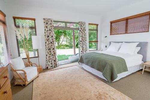 a bedroom with a bed and a large window at River View Escape close to Mount Maunganui & shops in Tauranga