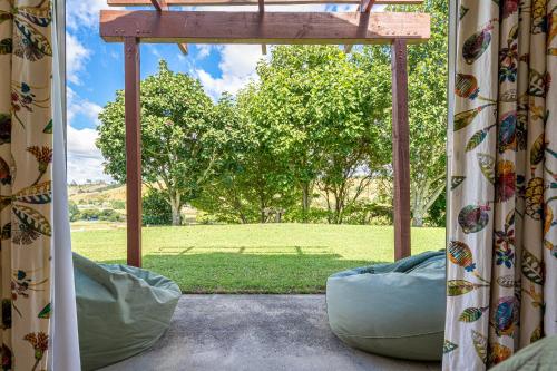 a screened in porch with a view of a field at River View Escape close to Mount Maunganui & shops in Tauranga