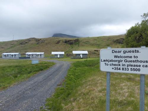 a sign next to a dirt road with buildings at Lækjaborgir Guesthouse in Kálfafell