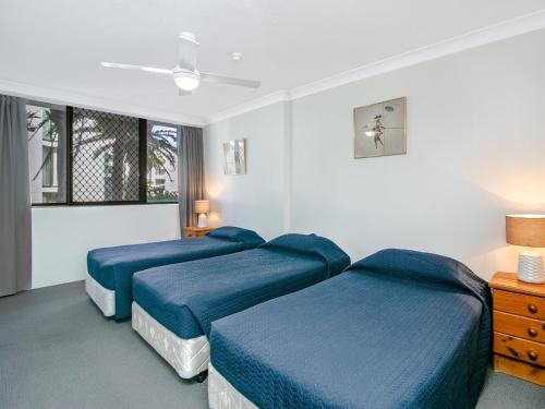 een hotelkamer met 3 bedden en een raam bij Aries Unit 5 in Gold Coast