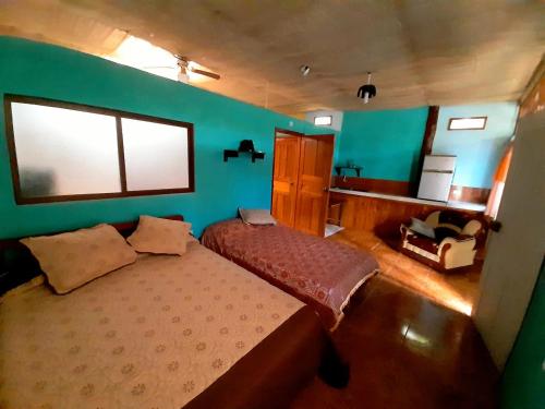 a bedroom with a bed and a blue wall at Alojamiento Sumak Kawsay in Puerto Ayora