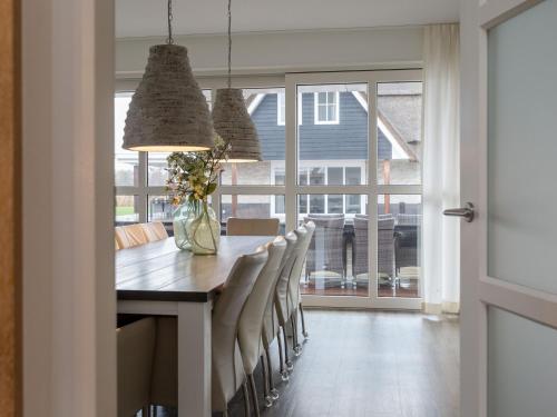 a dining room with a table and some chairs at Villa in Friesland with Sauna and Whirlpool in Delfstrahuizen