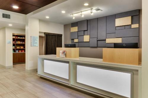a lobby with a counter with two white signs at Holiday Inn Express & Suites Waxahachie by IHG in Waxahachie