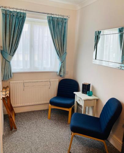 a living room with two chairs and a window at The Wentworth Guest House in Paignton