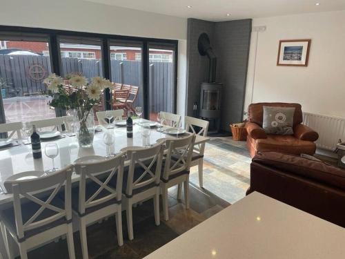 uma sala de jantar com uma mesa branca e cadeiras em Luxury Portrush Holiday Homes - The Glynn, Portrush Sleeps 12 - 5 bedrooms em Portrush