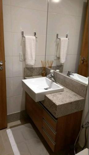 a bathroom with a white sink and a mirror at Flat Vista Azul Hotel in Pedra Azul
