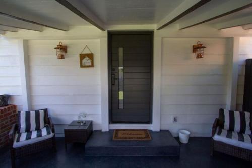 a front porch with two chairs and a door at Dreamy Farmhouse in Studio City in Los Angeles