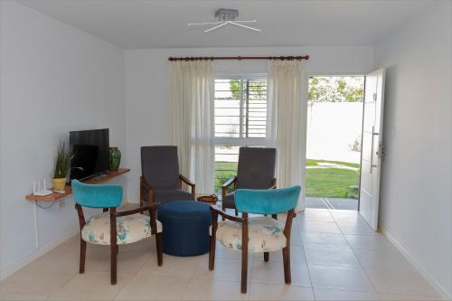 sala de estar con sillas, mesa y ventana en Departamento "Los López" en Mendoza