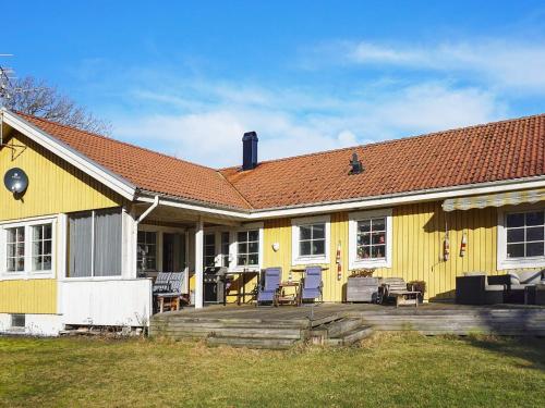a yellow house with a deck and chairs on it at 8 person holiday home in Grebbestad-By Traum in Grebbestad