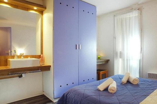 - une chambre avec une grande armoire bleue et des serviettes sur un lit dans l'établissement Gite in Soulac sur Mer for 6, à Soulac-sur-Mer