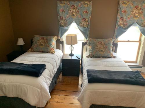 two beds sitting in a room with a window at Smugglers Notch Inn in Jeffersonville
