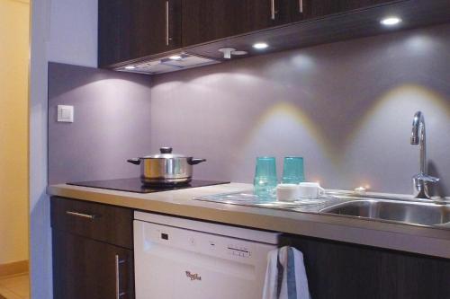 - une cuisine avec évier et pot sur le comptoir dans l'établissement Cozy Family Home for Getaways, à Soulac-sur-Mer