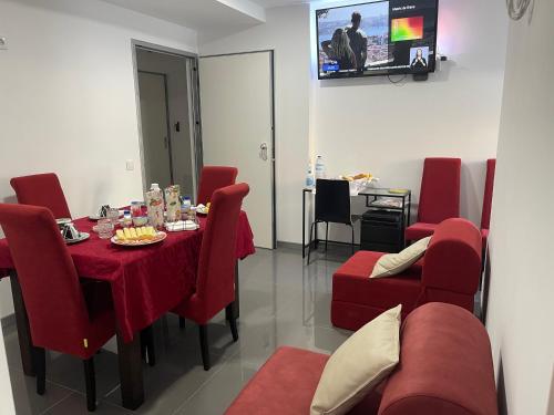 ein Esszimmer mit einem Tisch und roten Stühlen in der Unterkunft Ergosuites in Figueira da Foz