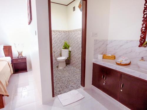 a bathroom with a sink and a toilet and a tub at Bali Laksita Homestay in Canggu