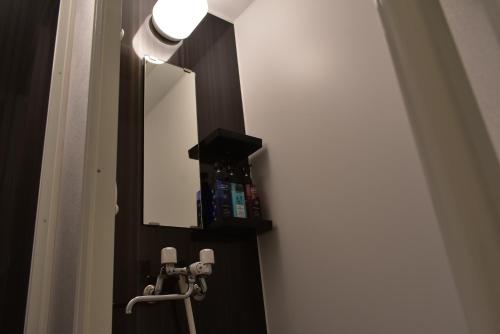 a bathroom with a mirror and a sink at GEORGE HOUSE in Tsuji in Naha