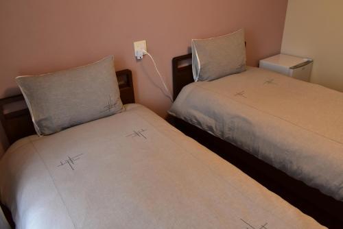 two beds sitting next to each other in a room at GEORGE HOUSE in Tsuji in Naha