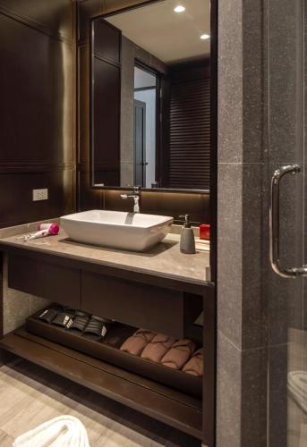 a bathroom with a sink and a mirror at The Pe La Resort, Phuket - SHA Extra Plus in Kamala Beach