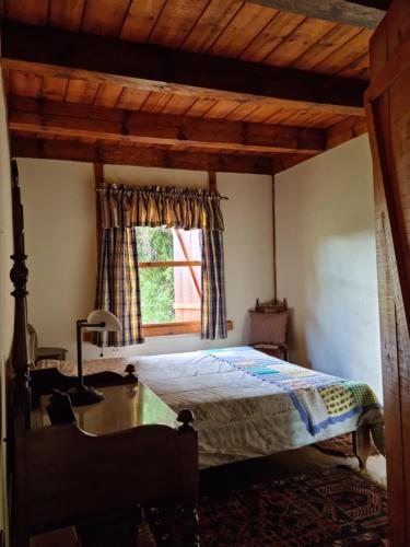 1 dormitorio con cama y ventana en Chalé na Serra da Mantiqueira, en Campos do Jordão