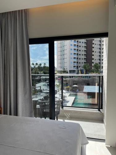 une chambre avec un lit et une grande fenêtre dans l'établissement Salinas Premium Resort - Salinópolis PA, à Salinópolis