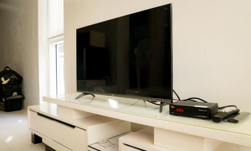 een flatscreen-tv op een wit entertainmentcentrum bij Pico de Loro Cove Hamilo Coast, Apartment 519, Corner Studio Unit, Jacana B Condominium in Nasugbu